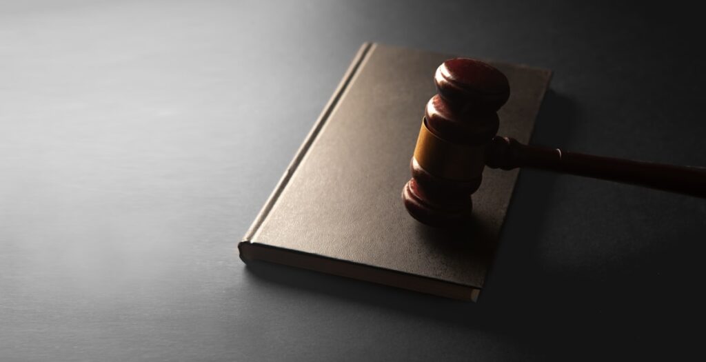 Wooden gavel resting on a closed law book – Texas employment and labor law attorney Jack Nichols